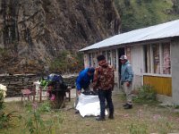 The porters encounter our duffles for the first time. Kaji helps out, Mingma watches and porter 1 waits