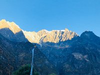 The morning light hits the peaks above