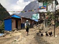 Village scene as we leave: water point, water fowl, ramshackle lodges, regional map, a sign about some USAID project, prayer flags